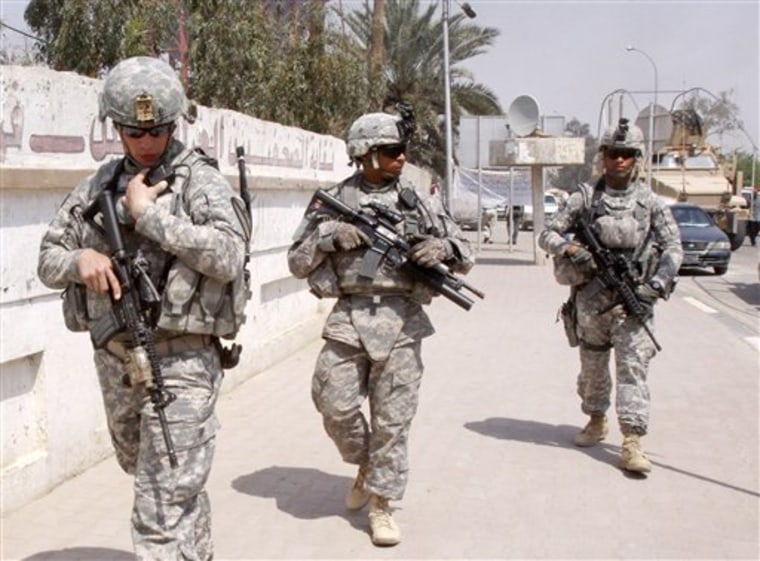 U.S. troops stand guard March 23 outside a local journalists' union office in Basra, Iraq. As the U.S. tries to move from invading power to normal diplomatic partner, the protection of American diplomats will fall almost entirely to private contractors and Iraqi security forces. 